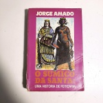 O Sumiço da Santa; uma história de feitiçaria. Jorge Amado. Idioma: Português. Rio de Janeiro, 1988. Editora Record. 438 páginas. Brochura. Livro em regular estado de conservação. Corte escurecido com oxidações. Capa, contracapa e lombada com marcas de manuseio e oxidações; parte da lombada descolada(miolo visível). Miolo com irregularidades e manchas de oxidação. Não possui grifo ou rasura.