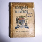 Centenário de Blumenau - 1850 2 de Setembro 1950. Idioma: Português. Editora Comissão de Festejos. 492 páginas. Brochura. Livro em regular estado de conservação. Corte escurecido com oxidações. Capa, contracapa e lombada com desgastes, fita, rasgos e oxidações; rasgos na base da capa; capa descolando. Miolo com manchas de oxidação, umedecimento e marcas de manuseio. Possui carimbo e rasura na capa e em diversas páginas.