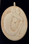 MARFIM, Pingente confeccionado em marfim, entalhado com figura de pensador de angola. Med.: 7x5cm.