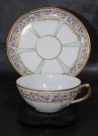 PORCELANA, Xícara para chá com seu respectivo pires em fina porcelana esmaltada na tonalidade branca, decorada com flores e folhagens em policromia, realces em ouro com perolados em relevo, marcado no fundo. Med.: 4,5x11x9,5cm.