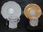 PORCELANA, Duas xícaras de coleção com seus respectivos pires em porcelana esmaltada, sendo: A) 1 com pintura furtacor na tonalidade abobora, com decoração em relevo, realces e inscrições em dourado, falhas na douração (4,5x6x4cm) e B) 1 na tonalidade branca, com elementos vegetalistas em relevo, filetado a ouro (falhas na douração) com pires adaptado (5,5x6,5x5cm).