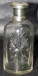 CRISTAL EUROPEU, Perfumeiro em cristal europeu translucido, lapidado por estrelas e sulcos em baixo relevo, tampa em metal espessurado a prata com cinzelado, bocal no estado. Med.: 14cm.