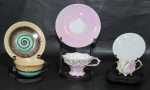 PORCELANA, Três xícaras de coleção com seus respectivos pires, sendo: A) 1 em porcelana esmaltada, decorado com flores em relevo na tonalidade rosa, apresenta fio de cabelo (5x9x7cm), B) 1 em porcelana esmaltada, pintura furtacor em policromia e realces em ouro (4x6x4cm) e C) 1 em cerâmica com pintura acidada em policromia (4x8,5x7cm).