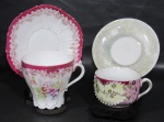 PORCELANA, Duas xícaras de coleção com seus respectivos pires em porcelana esmaltada, sendo: A) 1 da manufatura WEIMAR, GERMANY, com pintura de flores e folhagens em policromia, guirlanda floral em douração, borda na tonalidade rosa, apresenta fio de cabelo na xícara (9x11,5x9cm) e B) 1 na tonalidade branca, com decoração em relevo em policromia, flores e folhagens em dourado e pintura furtacor, pires adaptado (5,5x10x8cm).