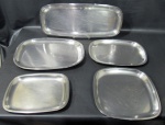 MERIDIONAL INOX, Conjunto de travessas em aço inox da manufatura MERIDIONAL, sendo 1 para peixe, 3 ovais e 1 quadrada. Med.: 52x22cm / 39x28,5cm / 34x24,5cm / 28x21cm e 29x29cm.