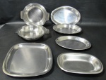 METAL INOX, Sete peças em aço inox, sendo: A) 2 panelas sem tampa da manufatura MERIDIONAL (7,5x27x23cm / 5x27x23cm), B) 4 travessas ovais (maior: 30x21cm / menor: 23x14cm) e 1 travessa quadrada (26x26cm).