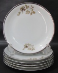 RENNER, Medaillon, Seis pratos rasos em porcelana esmaltada na tonalidade branca com pintura de flores e folhagens em policromia, borda filetada a prata. Med.: 25cm.