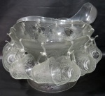 VIDRO, Poncheira com 12 xícaras em vidro translúcido, bordas onduladas, vidro ricamente trabalhado com frutos e folhagens. Acompanha concha em acrílico. Pé reversível, podendo virar um bowl. Medidas da poncheira 23 x 32 cm e das xícaras 7,5x9 cm.