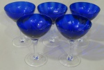 CRISTAIS, Cinco taças para champanhe em cristal na tonalidade azul, corpo canelado, haste sextavada e base circular translucida, 2 apresentam bicados. Med.: 13x9,5cm.