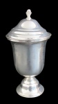 METAL PRATEADO, Potiche em metal espessurado a prata, tampa e base escalonadas, pega da tampa em formato de pinha. Banho novo. Med.: 32x16,5cm.