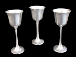 METAL PRATEADO, Três taças para vinho em metal espessurado a prata, haste cilíndrica terminada sobre base circular. Banho novo. Med.: 19x8cm.