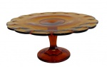 VIDROS, Prato para bolo de pé em vidro na tonalidade âmbar, lapidado por pingos, bordas onduladas, haste facetada e base circular. Med.: 12,5x28cm.