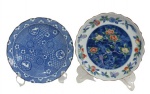 PORCELANA JAPONESA, Dois pratos em porcelana japonesa esmaltada, sendo; A) 1 com pintura de flores, folhagens e borboletas em rica policromia com borda filetada a ouro (19cm) e B) 1 com pintura de flores, paisagens e elementos geométricos na tonalidade azul (19cm).