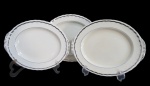 GRINDLEY, Inglaterra, Três travessas em faiança vitrificada, borda ondulada, espessa faixa em prata, apresenta craquele. Med.: 29,5x23,5cm / 27x22cm / 32x26cm.