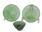 VIDROS, Três peças em vidro na tonalidade verde, sendo: A) 2 pratinhos, ricamente lapidado por cata ventos e elementos vegetalistas (14,5cm) e B) 1 petisqueira em formato de concha, com bicado (13x9,5cm).