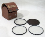 FOTOGRAFIA, Conjunto de lentes TIFFEN PHOTAR, acondicionada em caixa original em couro. com desgastes. Med.: 9x7,5x9,5cm.