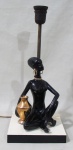 LUMINÁRIAS, Luminária para 1 lâmpada, estrutura em metal dourado, representando figura feminina africana em porcelana esmaltada sobre base de madeira. Apresentam falhas na esmaltagem. Med.: 34,5cm.