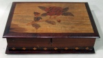DIVERSOS, Caixa porta joias em madeira com riquíssimo trabalho em marchetaria representando rosas e faixa com geométricos, interior com 2 estágios e 5 divisórias. Acompanha chave. Med.: 10x32,5x22cm.