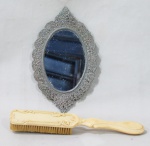 DIVERSOS, Lote com 2 peças, sendo: A) 1 escova em resina decorada com elementos vegetalistas (18,5cm) e B) 1 espelho em metal prateado ricamente cinzelado, apresenta oxidações no espelho (16x9,5cm).