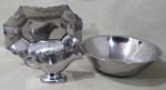 METAL PRATEADO, Três peças em aço inox, sendo: A) 1 fruteira ricamente cinzelada por elementos vegetalistas (32x23cm), B) 1 saladeira (10x30,5cm) e C) 1 molheira da manufatura WOLF (10x20x8cm).