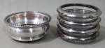 METAL PRATEADO, Lote com 2 peças, sendo: A) 1 porta garrafas em metal espessurado a prata, borda com decoração torcida (5x10,5cm) e B) 4 porta copos em vidro com guarnições em metal espessurado a prata italiano, apresenta sinais de oxidações (10cm).