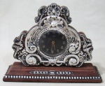 RELÓGIOS - Relógio de mesa em jacarandá com guarnição em prata de lei, ricamente decorada com elementos vegetalistas e perolados, da MARCA ORIS, máquina no estado. Med.: 14x18,5cm.