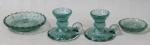 VIDRO, Quatro miniaturas em vidro na tonalidade verde, sendo A) 1 par de castiçais palmatória (5x6,5x6cm) e B) 2 pratinhos (8,5cm / 5,5cm). 1 castiçal possui defeito de fabrica.