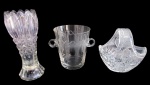 CRISTAIS/VIDROS, Lote com 3 peças, sendo: A) 1 vaso em vidro translucido, ricamente decorado, bordas onduladas, base facetada, apresenta rachado (20,5x8cm), B) 1 balde para gelo em cristal translucido, lapidado por X e folhagens em baixo relevo (14x12,5cm, ínfimos bicados na borda) e C) 1 cesta em cristal translucido, ricamente lapidado por estrelas e sulcos em baixo relevo (15x15x11cm).