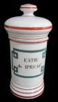 PORCELANA, Pote de farmácia em porcelana branca vitrificada, decorada com faixas na tonalidade vinho, centro com a inscrição "EXTR: de IPECAC:", pega da tampa em formato de disco. Medidas 26x9,5cm.