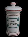 PORCELANA, Pote de farmácia em porcelana branca vitrificada, decorada com faixas na tonalidade vinho, centro com a inscrição "POM: deENXOFR:", pega da tampa em formato de disco. Medidas 26x9,5cm.