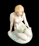 KARL ENS, Alemanha, Escultura em porcelana esmaltada representando nu feminino com pintura policromada, flores e folhagens em relevo. Marcada no fundo. Med.: 16,5x15x11,5cm.