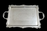ART PRATA, Bandeja retangular em metal espessurado a prata, ricamente cinzelada por elementos vegetalistas, borda com arabescos e concheados em relevo. Banho novo. Med.: 52x33cm.