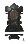 RELÓGIO ANSONIA CLOCK, Relógio de parede, em caixa confeccionada com madeira nobre ricamente entalhada, números em algarismos romanos, frente com vidro translucido, acompanha pêndulo e chave, peça no estado. Falta adorno superior. Não testado e sem garantia de funcionamento. Medidas: 58x33x10cm.