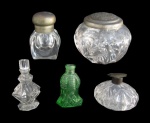 CRISTAIS/VIDROS, Lote com 5 peças, sendo: A) 3 perfumeiros em vidro, modelo e tonalidades distintas, no estado (9x11cm / 11cm), B) 1 porta talcos em vidro translucido com tampa em metal espessurada a prata, cinzelada com motivos florais, apresenta mossas e necessita banho (8x7cm) e C) 1 tinteiro em cristal translucido com tampa em metal espessurado a prata, possui mossas e discreto bicado no fundo (8cm).