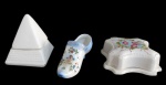 FAIANÇA, Lote com 3 peças. sendo: A) 1 caixa oitavada em faiança vitrificada com decoração perolada e pintura de flores e folhagens em policromia, bicados e trincados (5x13,5x13,5cm), B) 1 caixa em faiança vitrificada na tonalidade creme no formato de pirâmide (12x8x8cm) e C) 1 sapato em porcelana esmaltada na tonalidade branca, decoração na tonalidade azul com pintura de querubim, flores e folhagens em policromia (7x14x5cm).