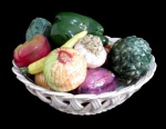 FAIANÇA, Cesta decorativa confeccionada em faiança vitrificada, decorada com frutos e vegetais em policromia, fixados na cesta, alguns descolados e bicados, possuem falhas na esmaltagem. Med.: 16x25cm.