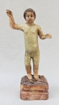ARTE SACRA, uma (1) antiga imaginária do Menino Jesus, século XIX/XX, entalhada em madeira, possui patina, olhos de vidro, faltam as vestes, medindo 22,5 cm altura, vide foto, pés com sinais de restauro, falhas na policromia e pequenas perdas como os dois dedos indicadores.