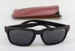 DIVERSOS, um (1) óculos OAKLEY, Made in USA, para sol, lentes com tecnologia Prizm, modelo Holbrook, preto com detalhes vermelhos, acompanha uma case adaptada; usado demanda limpeza, com defeitos.