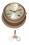 RELÓGIO HERMLE, Relógio de navio alemão, caixa em metal dourado, mostrador em metal com ranhuras, máquina original completa com chave, vidro frontal translucido (trincado), não testado e sem garantia de funcionamento. Med. 7x14cm.