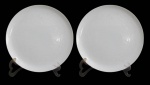 NORITAKE, Dois pratos para servir em porcelana esmaltada na tonalidade branca, com pintura de florões, arvoredos, gregas, chafariz e figuras realçadas em branco. Med.: 30,5cm.