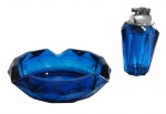 CRISTAIS, Cinzeiro e isqueiro de mesa em cristal na tonalidade azul com lapidação facetada. Med.: Isqueiro: 12cm / Cinzeiro: 16cm.