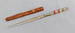 CUTELARIA NORDESTINA, um (1) pequeno punhal confeccionado artesanalmente, lâmina cromada e sem gume, cabo em polímero, bainha em couro, medindo 15 cm comprimento.