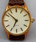 RELÓGIO, um (1) de pulso sem marca de manufatura aparente, movimento quartz, caixa em metal dourado, medindo 24 mm diâmetro, pulseira em couro, aparentemente em bom estado, parado e sem garantia, possivelmente demanda bateria.