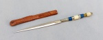 CUTELARIA NORDESTINA, um (1) pequeno punhal confeccionado artesanalmente, lâmina cromada e sem gume, cabo em polímero, bainha em couro, medindo 15 cm comprimento.