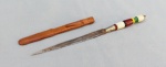 CUTELARIA NORDESTINA, um (1) pequeno punhal confeccionado artesanalmente, lâmina cromada e sem gume, com sinais de oxidação, cabo em polímero, bainha em couro, medindo 19 cm comprimento.