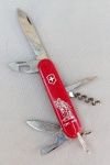 CUTELARIA, um (1) canivete Suíço, multifuncional, confeccionado em aço inox e outros materiais, manufatura VICTORIA, também conhecida como VICTORINOX (com tradição desde 1884, fornecedora de facas para o Exército Suíço desde 1897), medindo fechado 9 cm de comprimento, sinais de uso, vide foto, acondicionado na caixa original em papel cartonado faltando a tampa, comemorativo aos 700 anos do tratado de aliança realizado em 1291 entre os cantões Uri, Schwyz e Unterwalden, foi a primeira de uma série de alianças que fez emergir a Confederação Suíça.