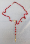 ARTE SACRA, um (01) terço com o crucifixo, a medalha com imagens de N. Sra. Aparecida e da Basílica e elos em metal dourado; as contas esféricas de vidro  vermelho; usado, faltam duas contas e algumas estão quebradas.