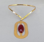BIJUTERIAS, um (01) colar aro, choker, liso, rígido com grande pingente central, ambos em metal dourado com cabochão sintético na cor âmbar escuro, medindo 40cm + 8cm o pingente.