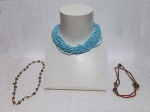 BIJUTERIAS, Três colares, sendo: A) 1 colar com contas de missangas na tonalidade azul com fecho de rosca (42cm) , B) 1 colar com missangas, pedras olho de tigre e metal dourado, fecho boia (77cm) e C) 1 colar com missangas, metal e cascalhos de olho de tigre, fecho lobster (54cm).