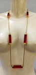 BIJUTERIAS, um (01) colar confeccionado em malha modelo Cartier Quadrado de metal dourado com retângulos de polímero vermelho intermediários, medindo 90cm; não possui fecho.